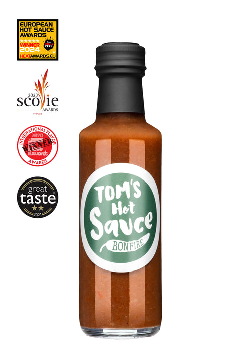 Flasche Hot Sauce „Bonfire" mit grünem Etikett auf weißem Hintergrund, umgeben von vier Auszeichnungen für Geschmack und Schärfe.